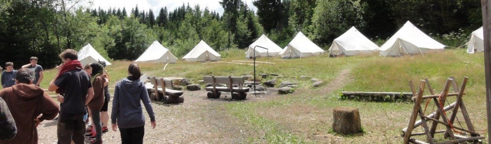 Bild Zeltplatz mit weißen Rundzelten und Feuerstelle