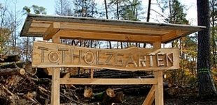 Großes Holzschild mit der Aufschrift "Totholzgarten".